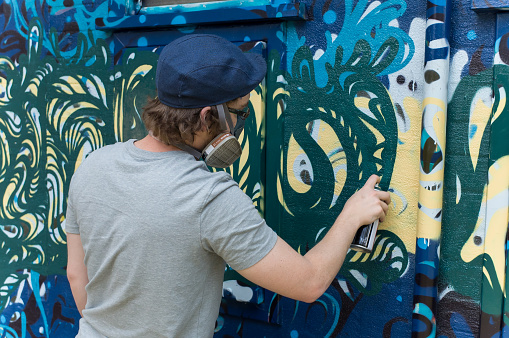 Blue Mountains, Australia - October 8, 2014: Council commissioned graffiti artist painting a wall in the Blue Mountains of Australia