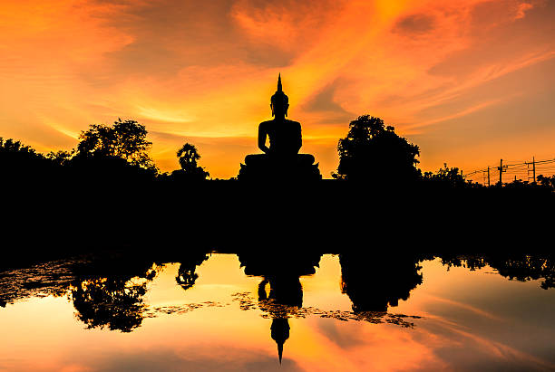 istock silhouette big buddha statue sitting reflection on the water 520134397