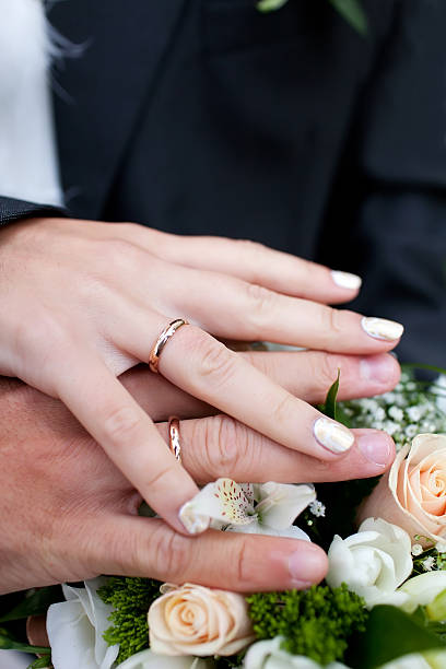 istock Hands with wedding rings on bridal bouquet 520134610