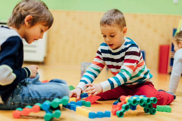 istock Cute Boys playing with blocks in kindergarten. 520134634
