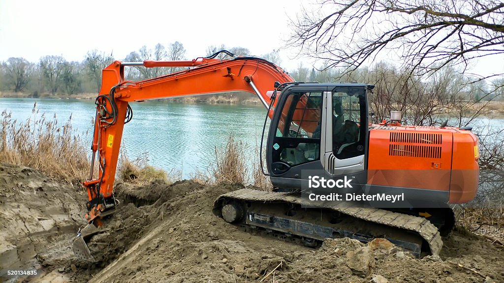excavator digs inflow into lake for a fish pass backhoe digs inflow to protect fish population in lake Backhoe Stock Photo