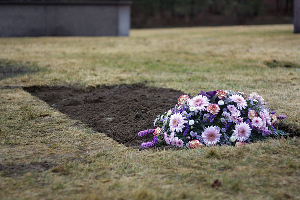 Flowers on Fresh Grave in Cemetery stock photo