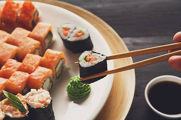 manger des sushis dans un restaurant japonais - maki sushi photos et images de collection