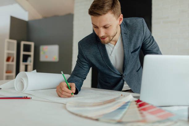 istock Architect Examining Blueprint In The Office. 520135180