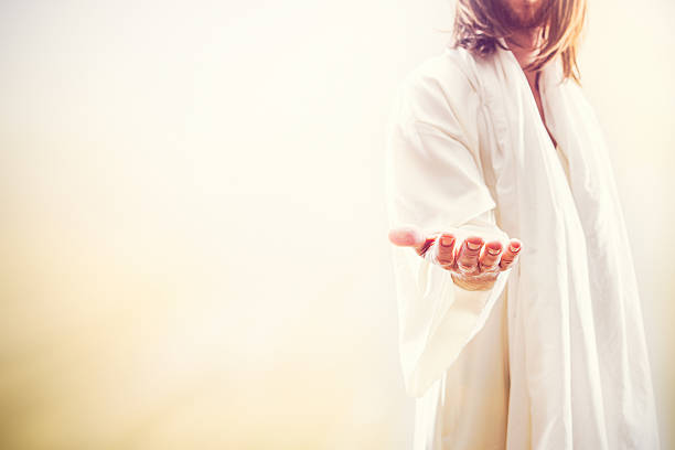 Jesus Christ Extending Welcoming Hand A representation of Jesus Christ following the resurrection in a heaven like setting, extending his hand with the invitation of new life.  His face is obscured, and bright golden light shines around him. A fitting image for Christ rising from the dead as celebrated on Easter Sunday. Horizontal image with copy space. jesus christ stock pictures, royalty-free photos & images