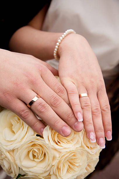 istock Hands with wedding rings on bridal bouquet 520135584