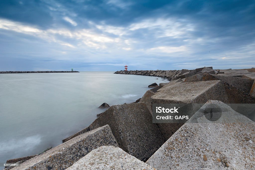 jetty at the entrance of Scheveningen' harbor cloudscap over the jetty at the entrance of the harbor at Scheveningen; Scheveningen Netherlands Beacon Stock Photo