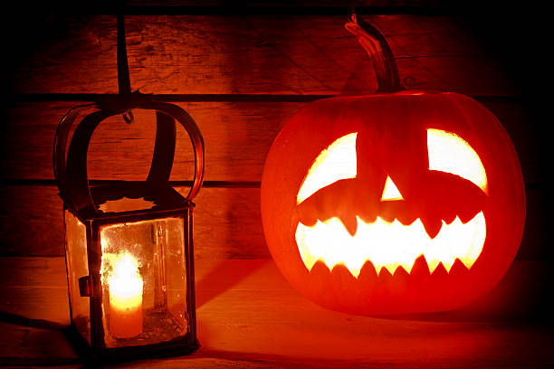 istock Halloween pumpkin with a candle on wooden background 520136071
