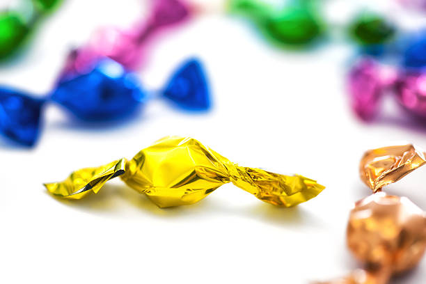 istock yellow candy sweets wrapped in aluminium foil 520137376