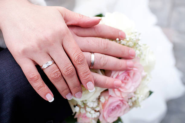 istock Hands with wedding rings on bridal bouquet 520137966