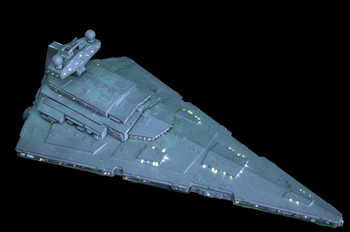 Vancouver, Canada - January 11, 2009: The wedge shape of a model Star Destroyer posed against a black background. The model is produced by the AMT model company and represents a spaceship from the Star Wars movie series.