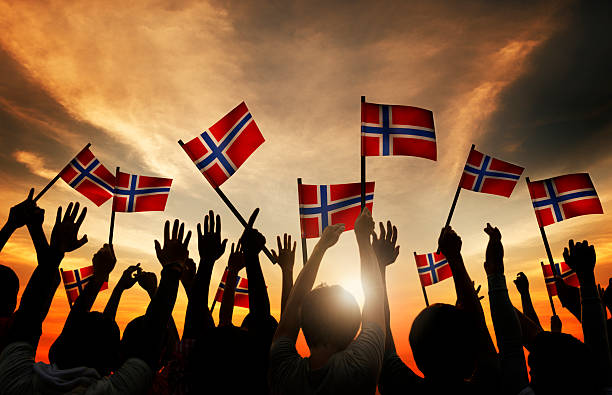 Group of People Waving Norwegian Flags in Back Lit Group of People Waving Norwegian Flags in Back Lit norwegian culture photos stock pictures, royalty-free photos & images