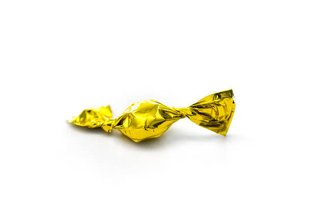 istock one yellow candy sweets wrapped in aluminium foil 520166198