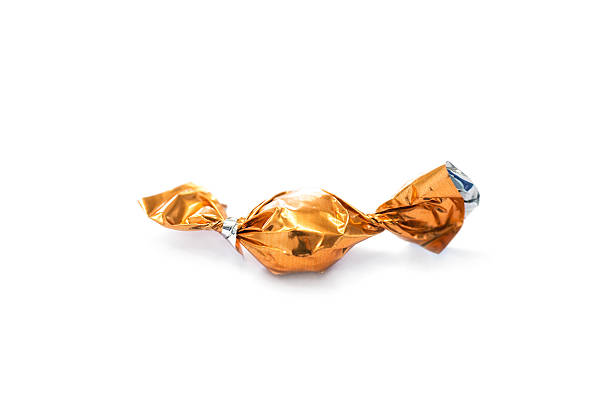 istock one orange candy sweets wrapped in aluminium foil 520166394