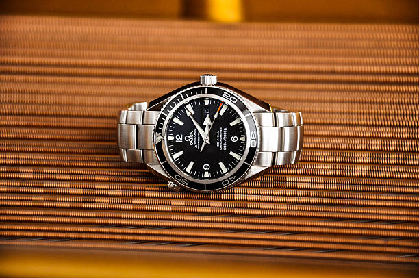 Munich, Germany - January 8, 2011: Omega Seamaster Planet Ocean wristwatch lying on the strings of a grand piano.