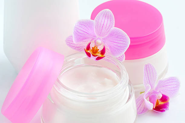istock Face creams and beautiful orchid flowers on white background 520167516