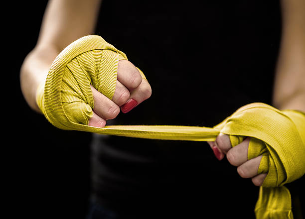 istock Woman is wrapping hands with yellow boxing wraps 520167564
