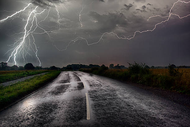 Road to hell Bolts of Lightning caught at the end of the road. lightning thunderstorm electricity cloud stock pictures, royalty-free photos & images