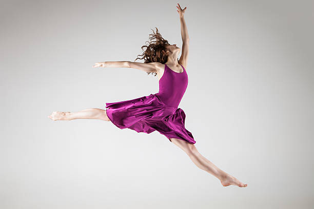 istock Young ballet dancer wearing purple dress over grey 520167861