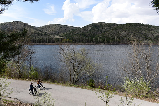 Ankara, Turkey - April 10, 2016: Two people are cycling near the Eymir Lake in Ankara. Eymir Lake recreational area is popular among citizens of Ankara at the weekends.