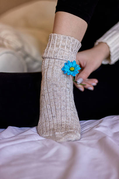 istock Woman holds a flower in hands lying in a bed 520169836