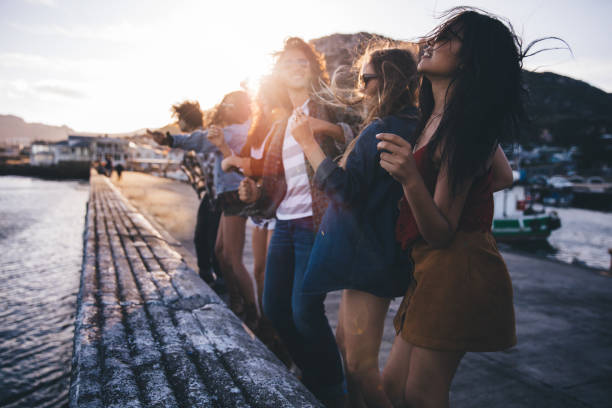 teen hipster amigos bailando en el muelle al anochecer - beach party friendship teenage girls fotografías e imágenes de stock