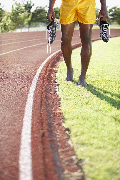 atleta de atletismo segurando seus sapatos - rivalry starting block track and field athlete track and field - fotografias e filmes do acervo