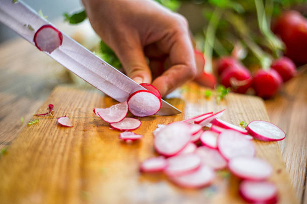 Cutting of garden radish for salad stock photo