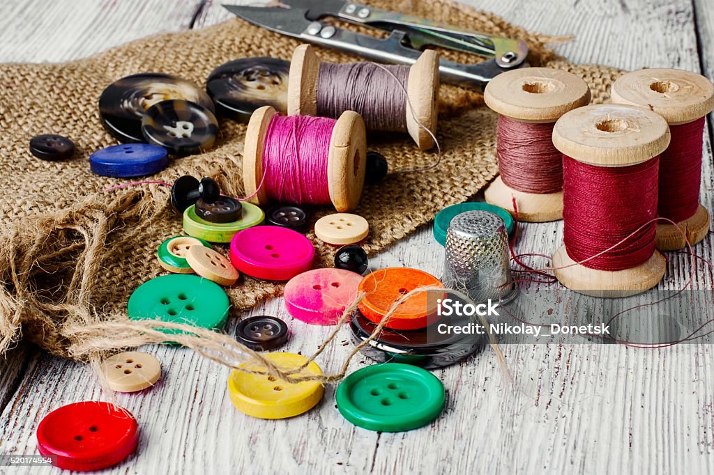 Colorful plastic buttons Set of several pied buttons for garment with threads on a bright background Sewing Stock Photo