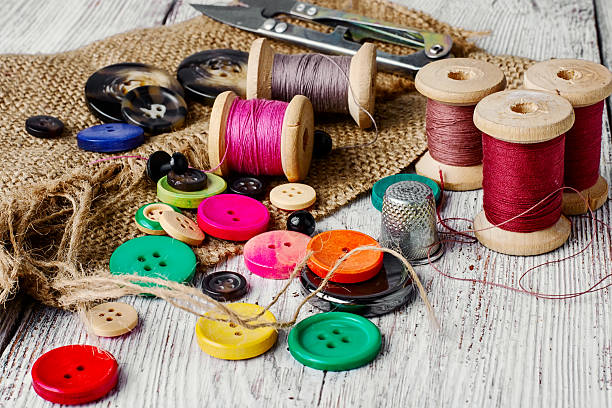 Colorful plastic buttons Set of several pied buttons for garment with threads on a bright background thread sewing item stock pictures, royalty-free photos & images