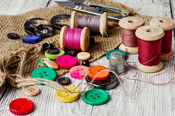 Colorful plastic buttons Set of several pied buttons for garment with threads on a bright background button sewing item stock pictures, royalty-free photos & images