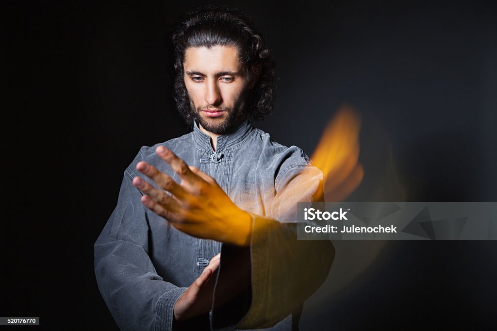 Man in kimono excercising Martial Arts Portrait of man in kimono excercising Martial Arts on black bacground with multiexposition Activity Stock Photo