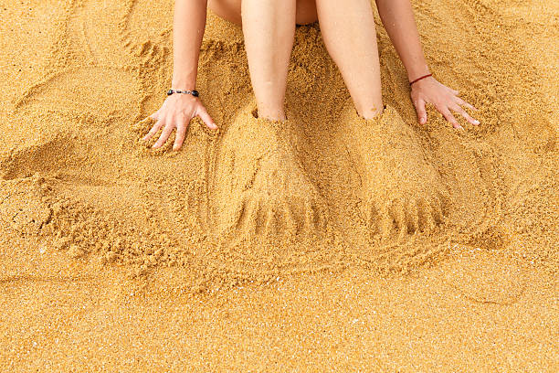istock Fun on the beach - human legs covered with sand 520178640