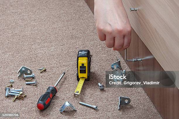 Closeup Of Carpenter Hand Tightens Fixing Screw Using Key Furniture Stock Photo - Download Image Now