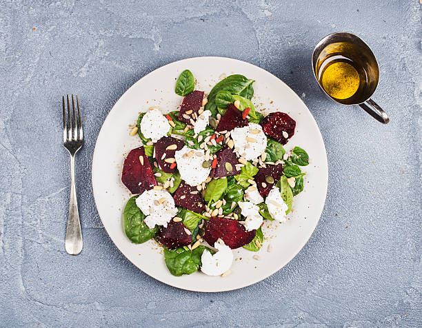 Salad with roasted beetroot, spinach, soft goat cheese and seeds stock photo