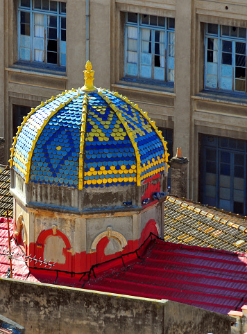 Béjaïa / Bougie, Kabylia, Algeria: dome of the synagogue with colorful tiles, red roofs and Ibn Sina highschool facade as background 