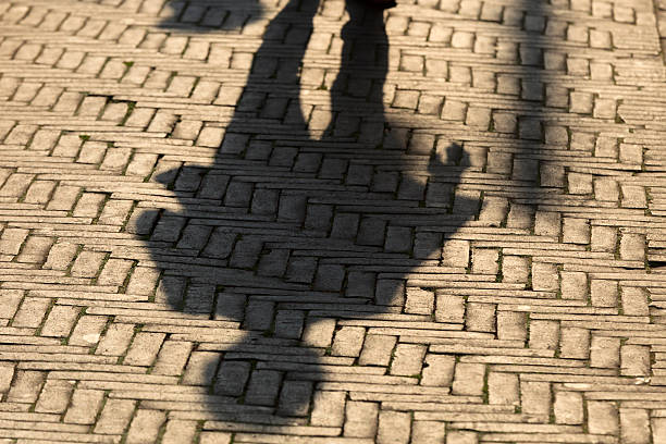 istock sun casting shadow over someone walking on the street 520191651