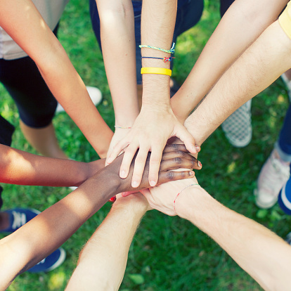 Above view of a large group of people with their hands gathered in the middle. They are standing in a circle. http://www.massimomerlini.it/is/lifestyles.jpg