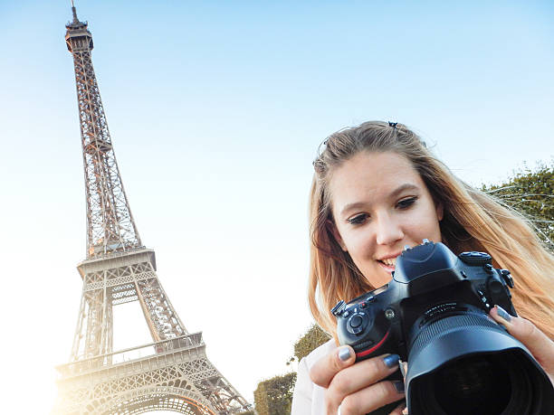 istock woman self photographing on paris ith the tour eiffel 520196997