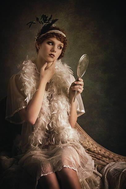 istock retro beauty lookin at herself in a silver hand mirror 520197435