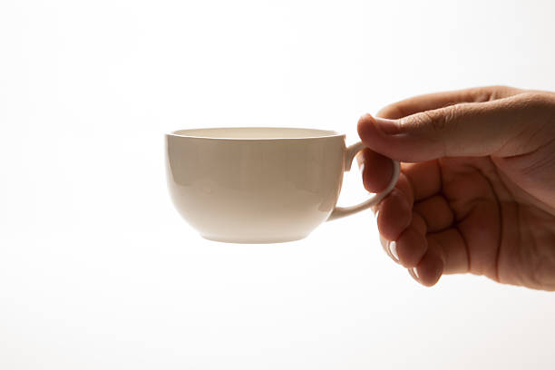 istock glass cup and saucer in hand closeup 520216261