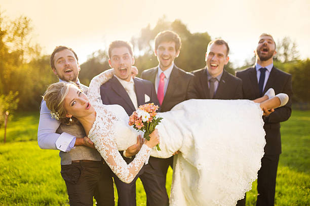 istock Groom with his friends holding bride 520216333