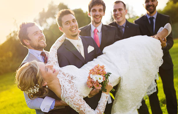 istock Groom with his friends holding bride 520216335