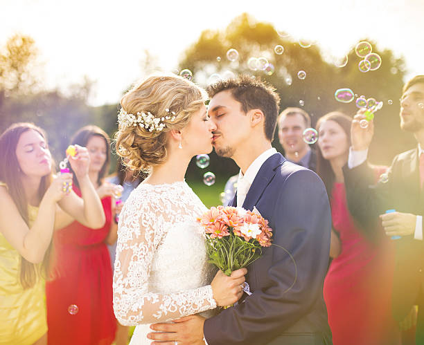 istock Newlyweds kissing at wedding reception 520216373