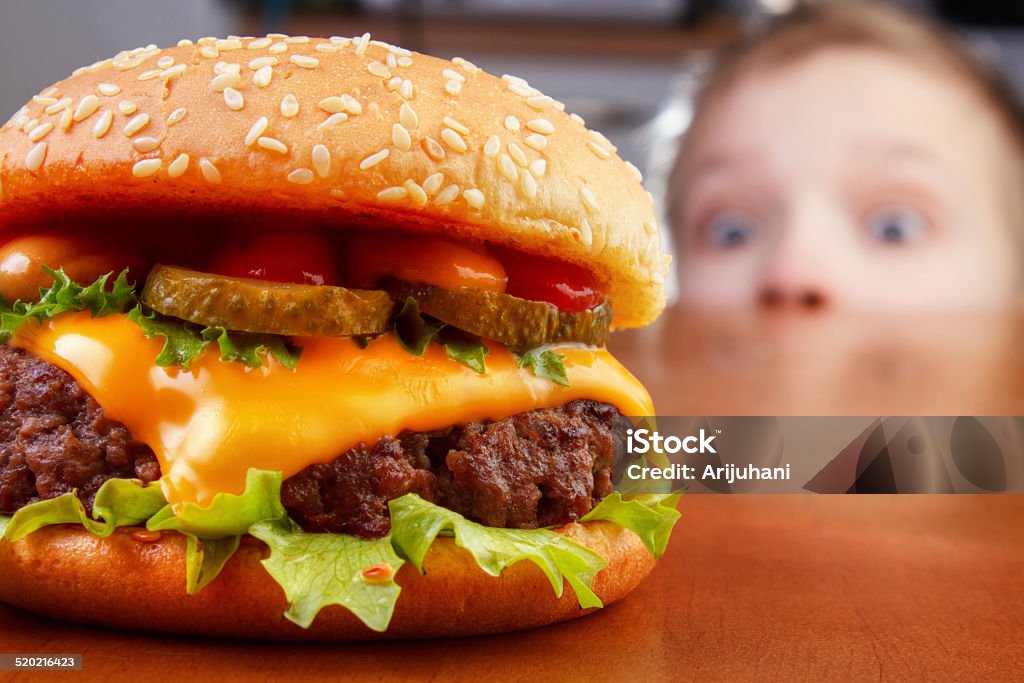 Kid oliendo hamburguesa - Foto de stock de Niño libre de derechos