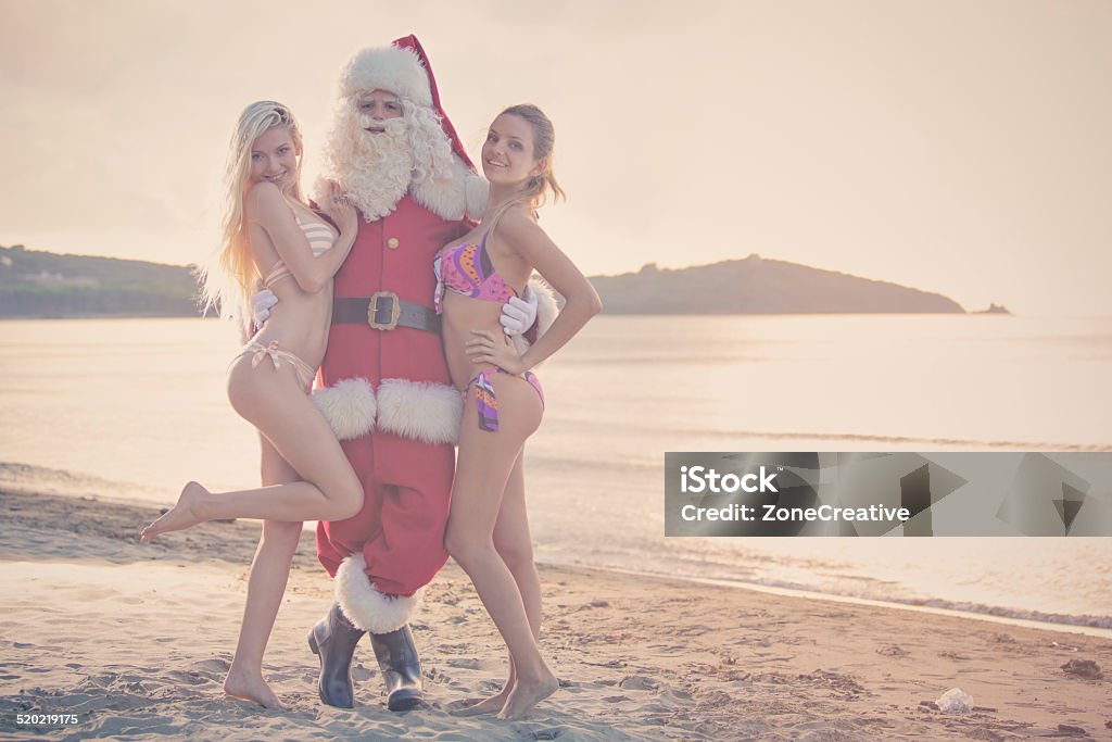 Santa Claus and beautiful girl standing at sunset on shore Adult Stock Photo