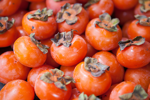 A basket full of orange persimmons.