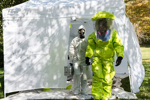 Two healthcare workers depart to the scene dressed in their hazmat gear.