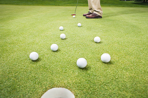 istock Golfer hitting ball through group of golf balls, low section 520221295