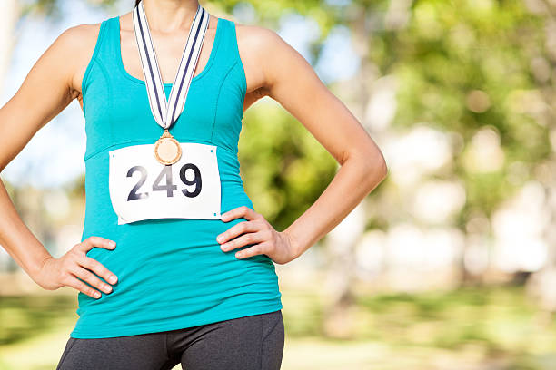 Marathon Gold Medalist Standing With Arms Akimbo At Park